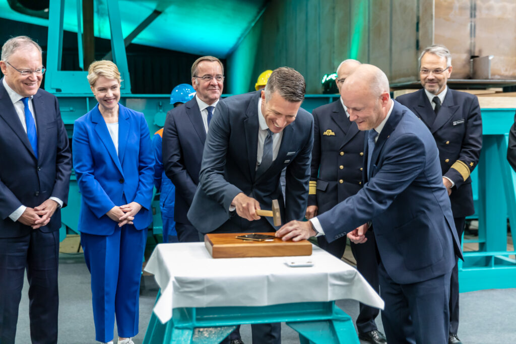 Projectdirecteur Frank Verhelst houdt de spijker vast terwijl zijn Blohm+Voss-collega Sascha Eilers de hamer hanteert.